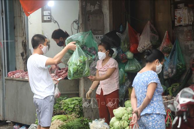 Trong ảnh: Cả người bán và người mua đều đeo khẩu trang để phòng, chống dịch. Ảnh: Thanh Tùng-TTXVN