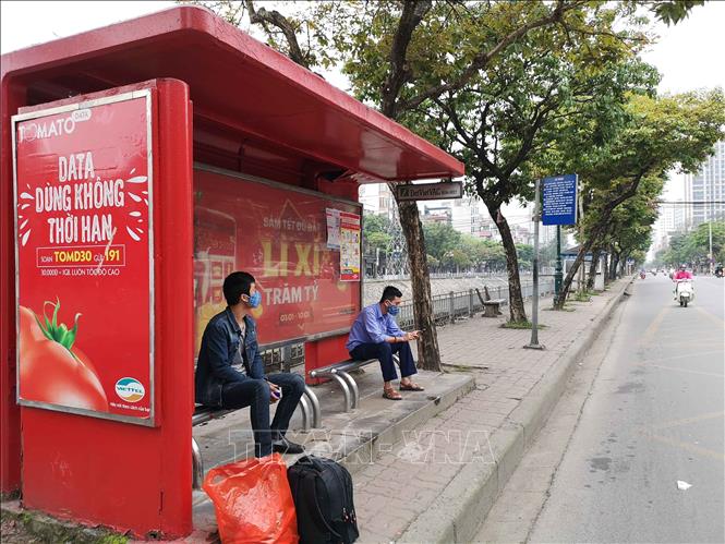 Trong ảnh: Điểm dừng đỗ trên phố Kim Ngưu trong sáng 28/3/2020 vẫn có người ra đón xe buýt vì không nắm được lịch ngưng hoạt động. Ảnh: Thanh Tùng-TTXVN