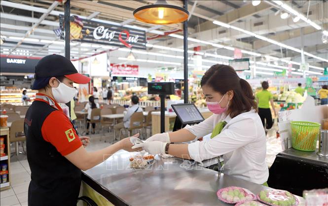 Trong ảnh: Nhân viên siêu thị Big C Vĩnh Phúc đeo khẩu trang khi phục vụ khách hàng. Ảnh: Hoàng Hùng -TTXVN