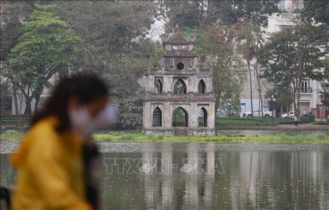 Trong ảnh: Hồ Hoàn Kiếm (Hà Nội) chỉ còn lác đác người dân đi dạo, tập thể dục song đều đeo khẩu trang để phòng dịch. Ảnh:TTXVN

