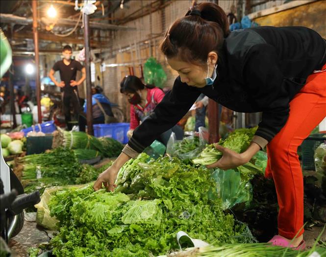 Trong ảnh: Người dân mua sắm rau xanh tại chợ Phùng Khoang trong ngày 1/4 - ngày đầu tiên thực hiện cách ly toàn xã hội. Ảnh: Vũ Sinh - TTXVN