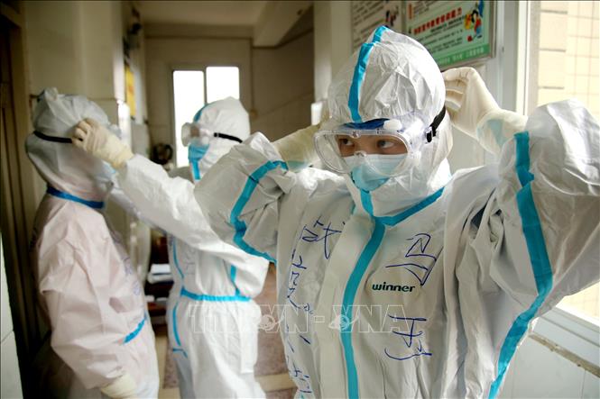 Trong ảnh: Nhân viên y tế mặc thiết bị bảo hộ trước khi tiếp cận bệnh nhân nhiễm COVID-19 tại bệnh viện Nhân dân ở Thập Yển, tỉnh Hồ Bắc, Trung Quốc ngày 8/3/2020. Ảnh: THX/TTXVN