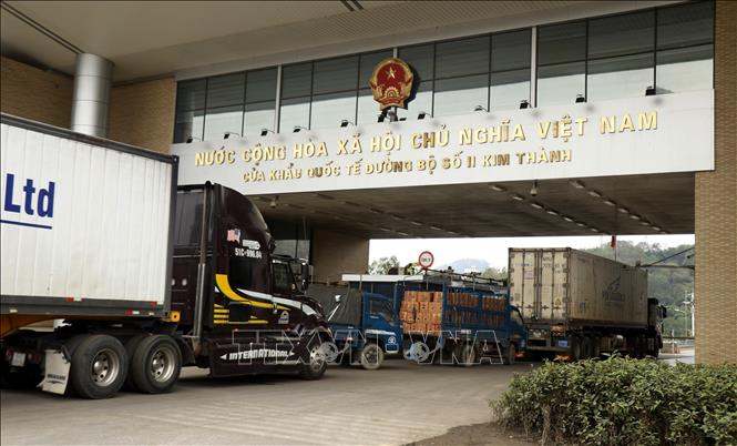 Photo: Trucks carry goods through Kim Thanh international land border gate No. 2 in Lao Cai province. VNA Photo: Quốc Khánh