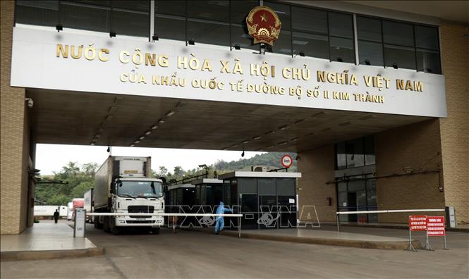 Photo: Trucks carry goods through Kim Thanh international land border gate No. 2 in Lao Cai province. VNA Photo: Quốc Khánh