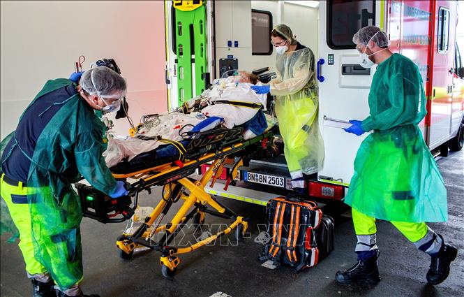 Trong ảnh: Nhân viên y tế chuyển bệnh nhân COVID-19 từ Bergamo (Italy) tới điều trị tại bệnh viện ở Bonn, miền Tây Đức ngày 28/3/2020. Ảnh: AFP/TTXVN