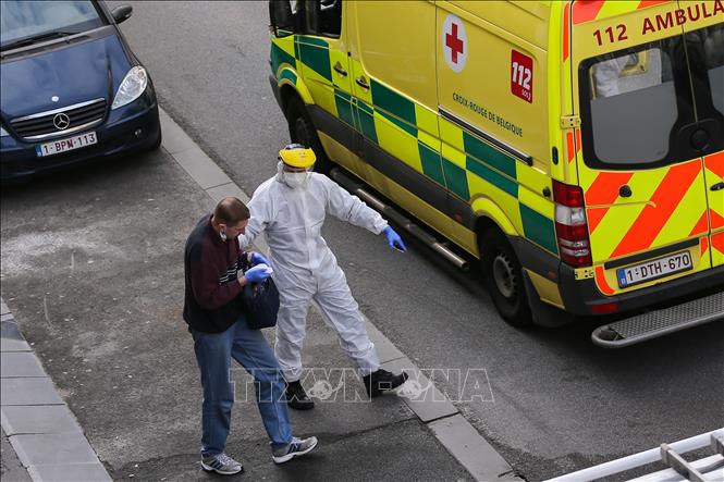 Trong ảnh: Nhân viên y tế hướng dẫn một bệnh nhân nghi nhiễm COVID-19 lên xe cứu thương tại Brussels, Bỉ, ngày 2/4/2020. Ảnh: THX/TTXVN