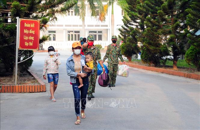 Cán bộ, chiến sĩ Trường Quân sự tỉnh Thừa Thiên- Huế hỗ trợ người dân hoàn thành thời gian cách ly vận chuyển đồ đạc ra xe. Ảnh: TTXVN phát