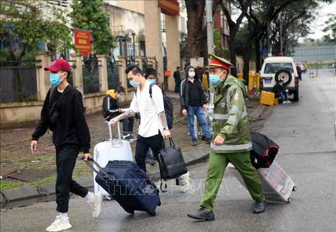 Trong ảnh: Do lượng người hoàn thành cách ly lớn nên lực lượng Công an quận Hoàng Mai tham gia giúp đỡ mang hành lý ra khỏi khu nhà. Ảnh: Danh Lam – TTXVN