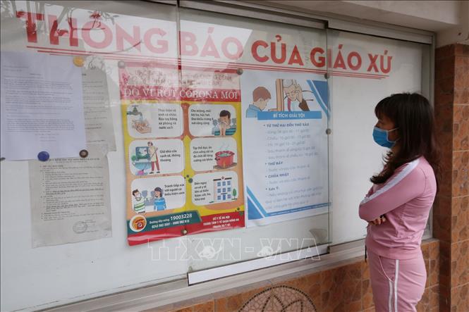 Trong ảnh: Một giáo dân xem các thông tin về dịch COVID-19 tại Nhà thờ Giáo xứ Thái Hà. Ảnh: Anh Tuấn – TTXVN