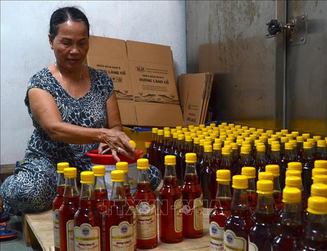 Photo: Nam O village’s fish sauce is bottled. VNA Photo: Quốc Dũng