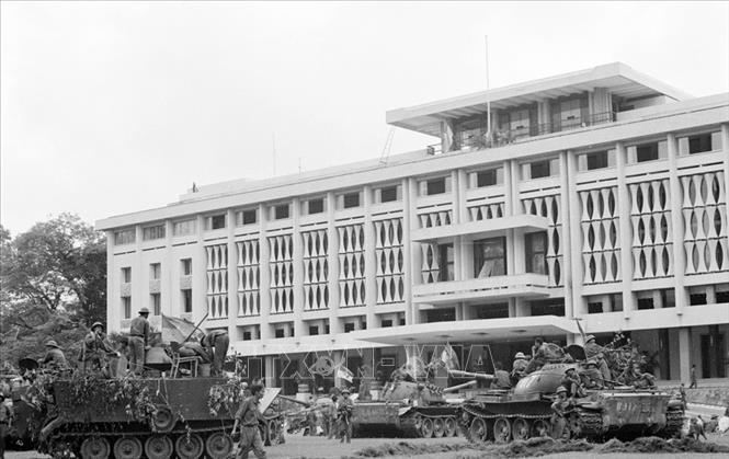 Trong ảnh: Xe tăng và bộ binh quân giải phóng chiếm phủ Tổng thống ngụy quyền Sài Gòn, trưa 30/4/1975. Ảnh: Mai Hưởng – TTXVN
