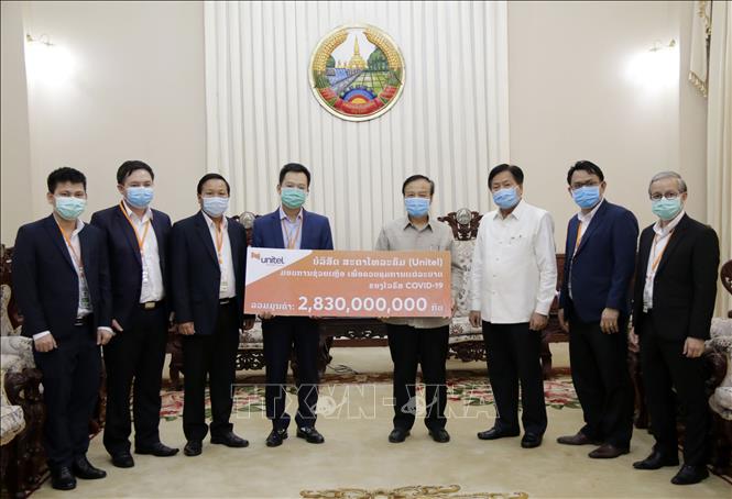 Trong ảnh: Ông Lưu Mạnh Hà, Tổng Giám đốc Công Ty Star Telecom (trái) trao tượng trưng số tiền 2.830.000.000 kip (tương đương 320.000 USD) cho Phó Thủ tướng, Bộ trưởng Tài chính, Trưởng Ban Chỉ đạo Quốc gia phòng, chống dịch COVID-19 của Lào Somdy Duangdy. Ảnh: Phạm Kiên – Phóng viên TTXVN tại Lào
