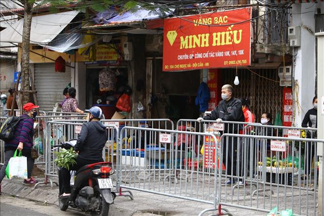 Trong ảnh: Lực lượng chức năng phường Đội Cấn (Ba Đình) lập hàng rào phía bên ngoài chợ Ngọc Hà. Ảnh: Minh Quyết - TTXVN

