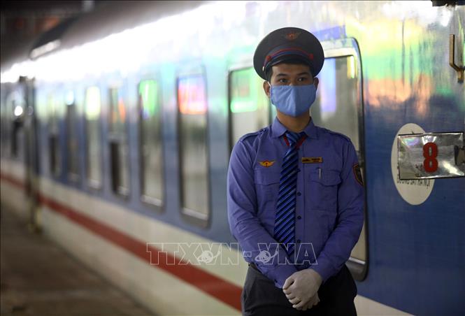 Trong ảnh: Nhân viên đường sắt trong thời điểm này đều phải đeo khẩu trang y tế và đeo găng tay. Ảnh: Huy Hùng – TTXVN