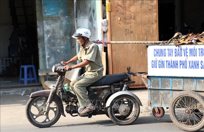 Trong ảnh: Sau hơn 2 giờ làm việc buổi sáng, ông Nguyễn Ngọc Đức chở số rác đã vớt trên kênh Chiến Lược đến nơi tập kết rác của Thành phố. Ảnh: Xuân Khu-TTXVN.