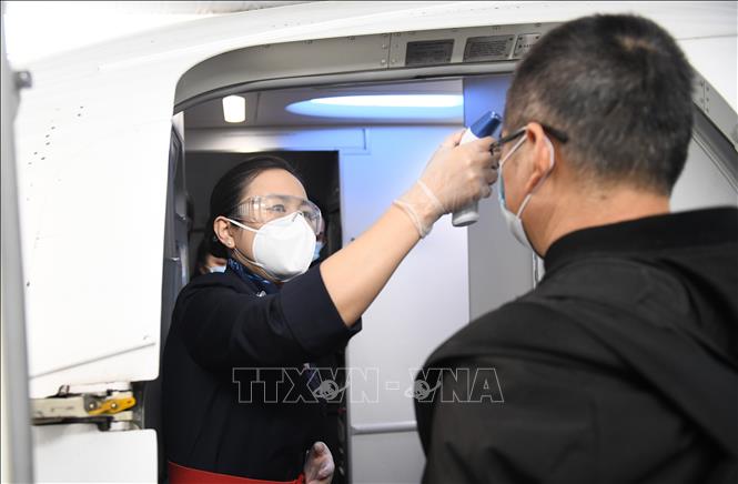Trong ảnh: Nhân viên kiểm tra thân nhiệt của hành khách tại sân bay ở Vũ Hán, tỉnh Hồ Bắc, Trung Quốc, sau khi lệnh phong tỏa được gỡ bỏ ngày 8/4/2020. Ảnh: THX/ TTXVN