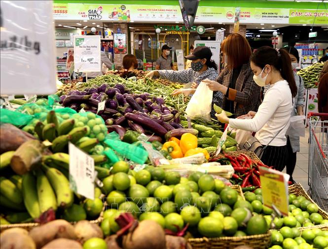 Trong ảnh: Người dân chọn mua sắm tại quầy hàng rau, củ, quả trong siêu thị Big C Thăng Long. Ảnh: Vũ Sinh - TTXVN