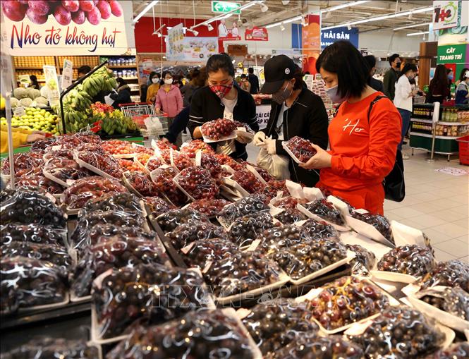 Trong ảnh: Người dân chọn mua sắm tại quầy hàng rau, củ, quả trong siêu thị Big C Thăng Long. Ảnh: Vũ Sinh - TTXVN