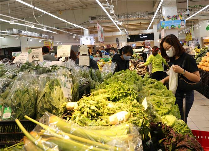 Trong ảnh: Người dân chọn mua sắm tại quầy hàng rau, củ, quả trong siêu thị Big C Thăng Long. Ảnh: Vũ Sinh - TTXVN