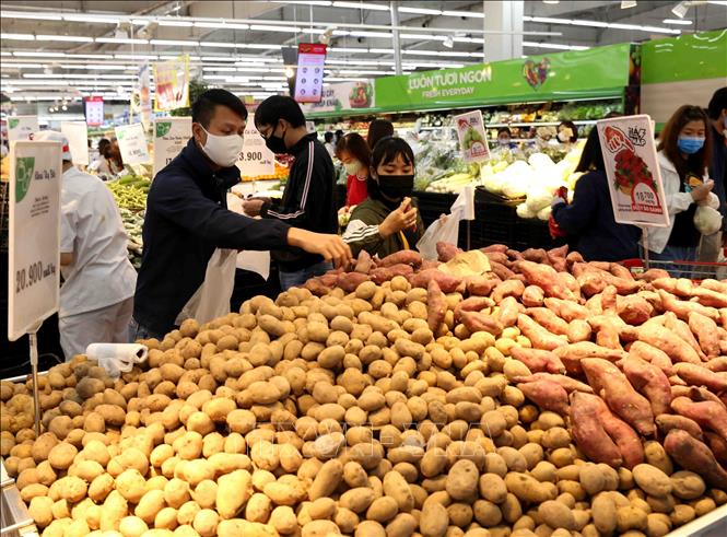 Trong ảnh: Người dân chọn mua sắm tại quầy hàng rau, củ, quả trong siêu thị Big C Thăng Long. Ảnh: Vũ Sinh - TTXVN