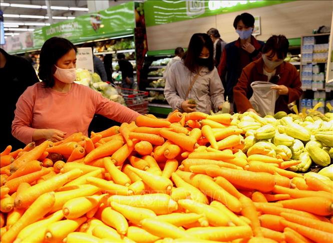 Trong ảnh: Người dân chọn mua sắm tại quầy hàng rau, củ, quả trong siêu thị Big C Thăng Long. Ảnh: Vũ Sinh - TTXVN