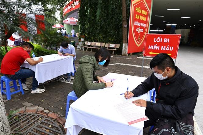 Trong ảnh: Người tham gia hiến máu tình nguyện kê khai thông tin, được bố trí ngồi đúng khoảng cách quy định. Ảnh: Minh Quyết – TTXVN