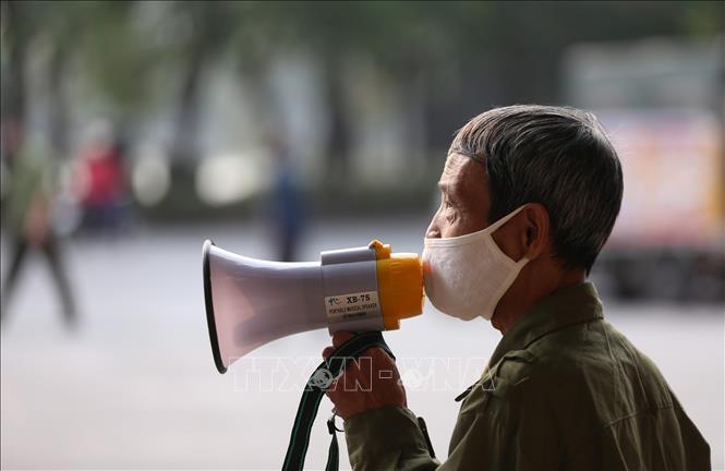 Trong ảnh: Lực lượng chức năng phường Lý Thái Tổ sử dụng loa cầm tay nhắc nhở người dân không có việc cấp thiết không ra khỏi nhà những ngày thực hiện giãn cách xã hội. Ảnh: Anh Tuấn – TTXVN