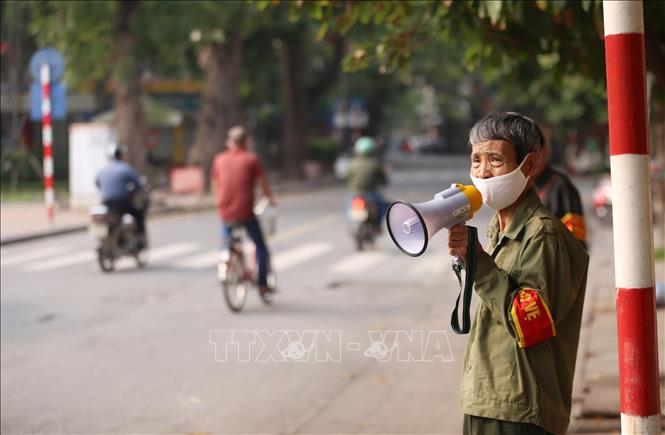 Trong ảnh: Lực lượng chức năng phường Lý Thái Tổ sử dụng loa cầm tay nhắc nhở người dân không có việc cấp thiết không ra khỏi nhà những ngày thực hiện giãn cách xã hội. Ảnh: Anh Tuấn – TTXVN
