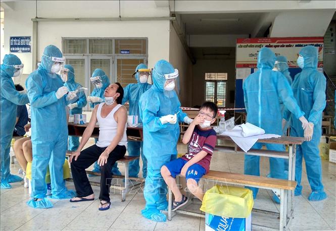 Photo: Doctors provide health check-ups and get test samples at a quarantine area in HCM City. VNA Photo