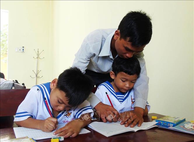 Trong ảnh: Thầy giáo Nguyễn Ngọc Hạ dạy viết chữ cho học sinh là con cán bộ, chiến sĩ, nhân dân trên xã đảo Sinh Tồn. Ảnh: Nguyên Lý - TTXVN