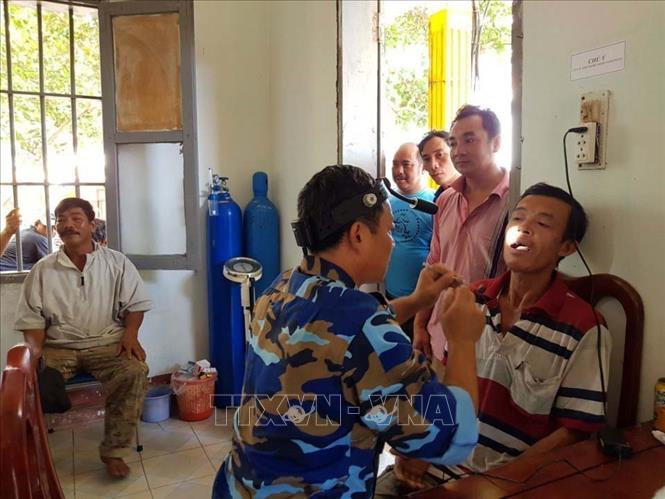 Trong ảnh: Quân y đảo Sinh Tồn, huyện đảo Trường Sa (tỉnh Khánh Hòa) khám, chữa bệnh cho ngư dân đang neo đậu tàu cá tránh trú bão số 9 (11/2018). Ảnh: TTXVN phát