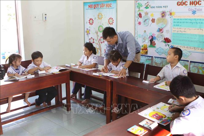 Trong ảnh: Thầy giáo Lê Xuân Quyết hướng dẫn học sinh xã đảo Song Tử Tây. Ảnh: Dương Giang - TTXVN