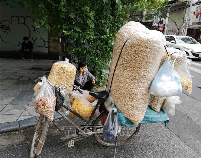 Trong ảnh: Chiều 12/4, những người bán hàng rong vẫn đi tới nhiều ngõ, phố của Hà Nội để bán hàng tiềm ẩn nguy cơ lây lan dịch bệnh. Ảnh: Thanh Tùng-TTXVN