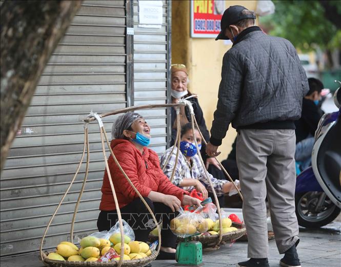 Trong ảnh: Trong lúc bán hàng, người mua hay người bán vô tình bỏ khẩu trang rất dễ lây lan dịch bệnh. Ảnh: Thanh Tùng-TTXVN