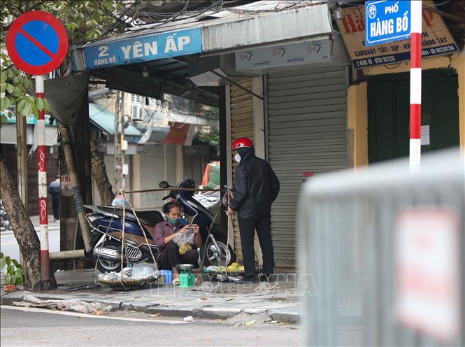 Trong ảnh: Chiều 12/4, những người bán hàng rong vẫn đi tới nhiều ngõ, phố của Hà Nội để bán hàng tiềm ẩn nguy cơ lây lan dịch bệnh. Ảnh: Thanh Tùng-TTXVN