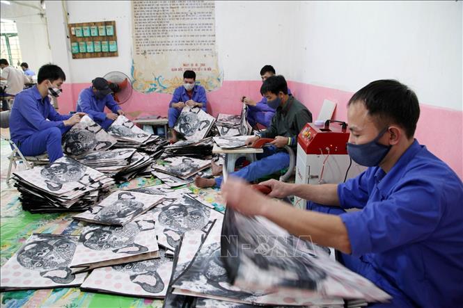 Trong ảnh: Các học viên đang cai nghiện tại Cơ sở cai nghiện ma túy số 2 Hà Nội đều đeo khẩu khang đầy đủ khi lao động trị liệu. Ảnh: Anh Tuấn – TTXVN