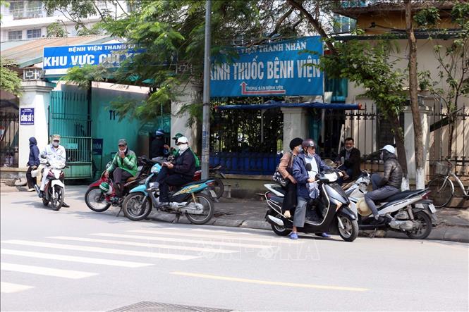 Trong ảnh: Cảnh tụ tập đông người không đúng giãn cách xã hội trước cổng Bệnh viện Thanh Nhàn. Ảnh: Anh Tuấn – TTXVN