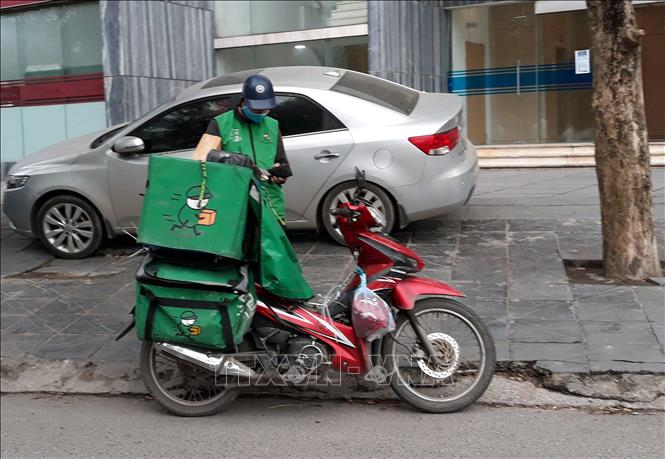 Trong ảnh: Người chuyển hàng (shipper) bận rộn trong mùa dịch. Ảnh: Đỗ Phương Anh-TTXVN