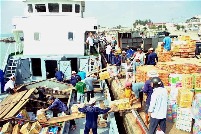 Trong ảnh: Bốc xếp hàng lên tàu tại cảng Phan Thiết để vận chuyển ra đảo Phú Quý. Ảnh : Anh Tuấn - TTXVN