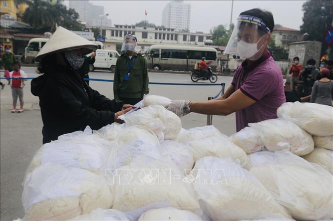 Trong ảnh: Người dân nhận gạo tại điểm phát trường Đại học Kinh tế Quốc dân. Ảnh: Trần Việt - TTXVN 