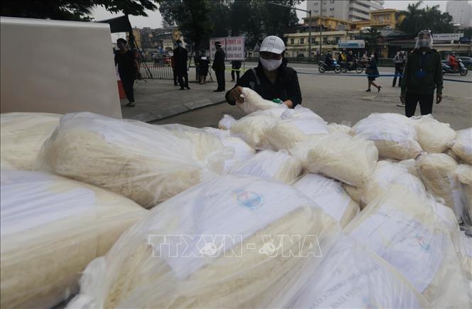Trong ảnh: Gạo được phát miễn phí tại cổng trường và Trung tâm Văn hoá quận Hai Bà Trưng. Ảnh: Trần Việt - TTXVN 