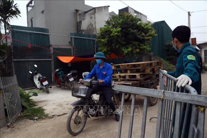Trong ảnh: Kiểm soát chặt chẽ người dân trong xã Dũng Tiến đi lại, đồng thời hạn chế không cho người ngoài vào thôn Đông Cứu. Ảnh: Minh Quyết - TTXVN
