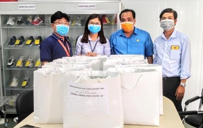 Trong ảnh: Đại diện Công đoàn các khu công nghiệp tỉnh An Giang tặng dung dịch nước rửa tay khô và khẩu trang y tế cho phòng dịch COVID0-19 cho các doanh nghiệp đóng tại Khu công nghiệp Bình Hòa, huyện Châu Thành. Ảnh: Công Mạo - TTXVN