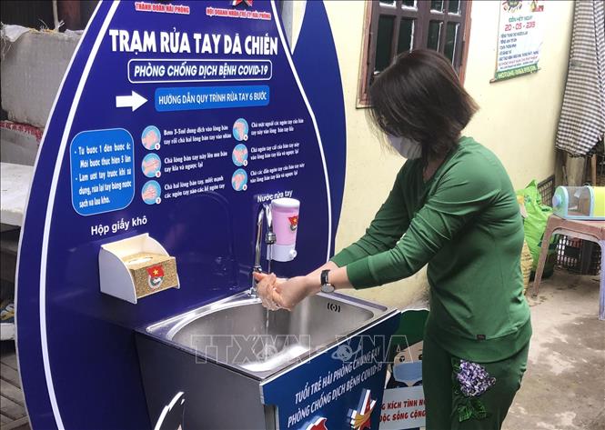 Trong ảnh: Người dân rửa tay tại trạm rửa tay dã chiến. Ảnh: TTXVN