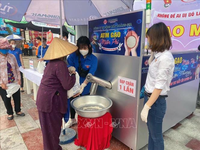 Trong ảnh: Đoàn viên thanh niên hỗ trợ người dân nhận gạo. Ảnh: Hoàng Ngọc - TTXVN