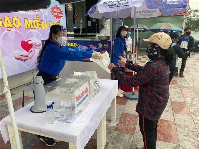 Trong ảnh: Đoàn viên thanh niên hỗ trợ người dân nhận gạo. Ảnh: Hoàng Ngọc - TTXVN  