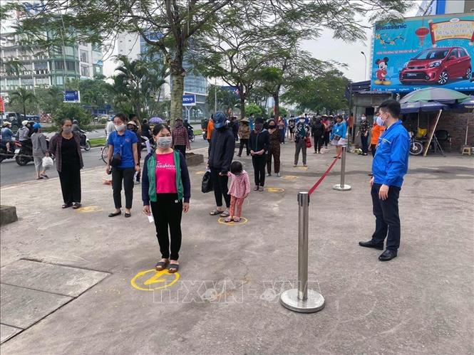 Trong ảnh: Người có hoàn cảnh khó khăn xếp hàng nhận gạo. Ảnh: Hoàng Ngọc - TTXVN  