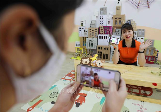 Trong ảnh: Cô giáo trường Mầm non Tràng An, quận Thanh Xuân (Hà Nội) ứng dụng phần mềm công nghệ để chèn âm thanh lên ảnh, tạo video tiết kể chuyện cho trẻ hấp dẫn và lôi cuốn hơn.  Ảnh: Thanh Tùng - TTXVN 