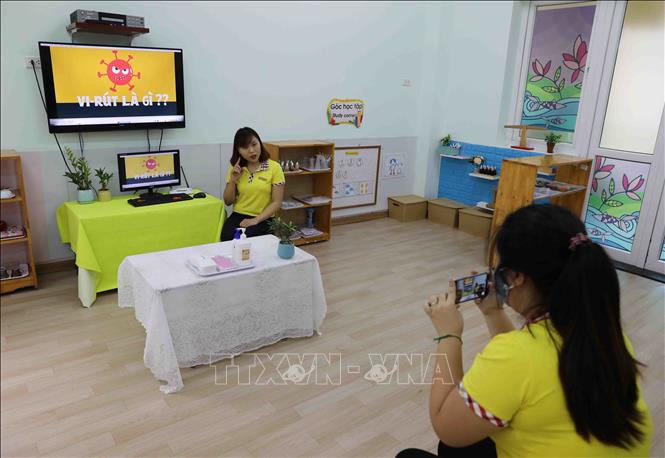 Trong ảnh: Giáo viên trường Mầm non Thanh Xuân Trung làm bài giảng điện tử dạy học sinh cách phòng chống Virus. Ảnh: Thanh Tùng - TTXVN