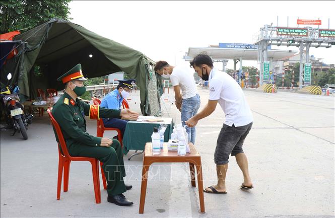 Trong ảnh: Người dân rửa tay khử trùng trước khi khai báo y tế với lực lượng chức năng. Ảnh: Đinh Tuấn - TTXVN